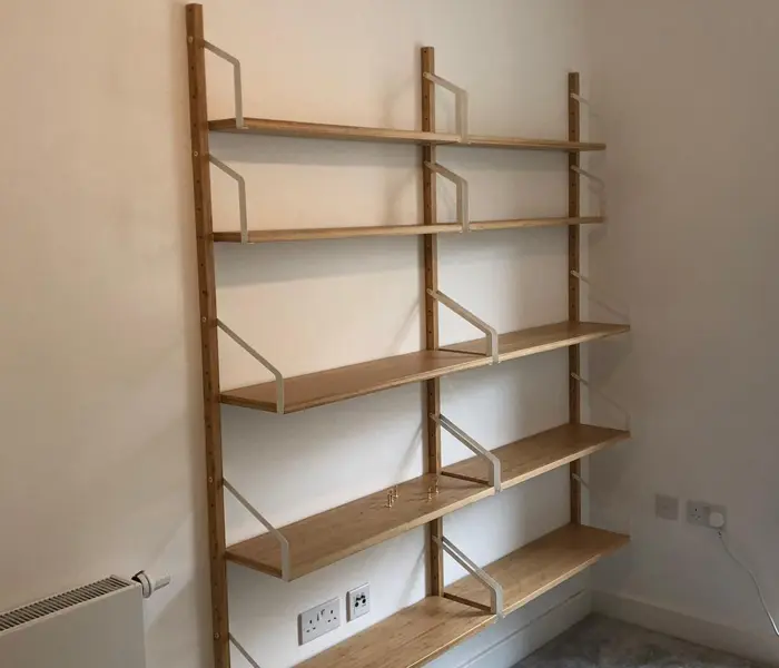 Floating white shelves securely mounted on a brick wall for home storage